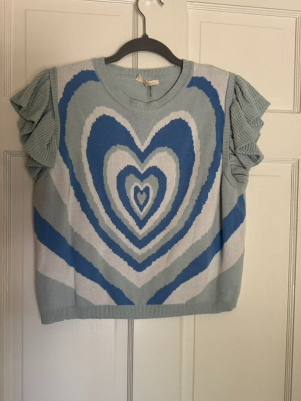 Sleeveless blue knit top with layered heart graphic